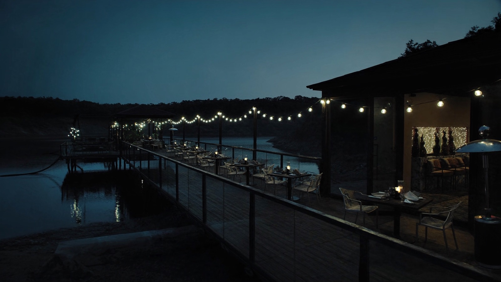 The waterfront terrace at Citron Baltimore glowing at dusk over Quarry Lake